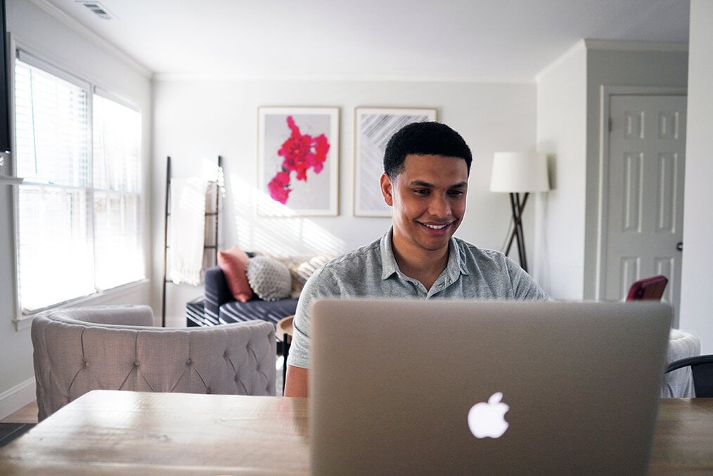 A young adult working on a MacBook 